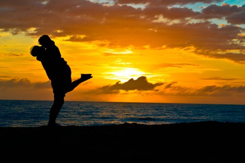 Free Silhouette of Two Couple Standing on Seashore Stock Photo